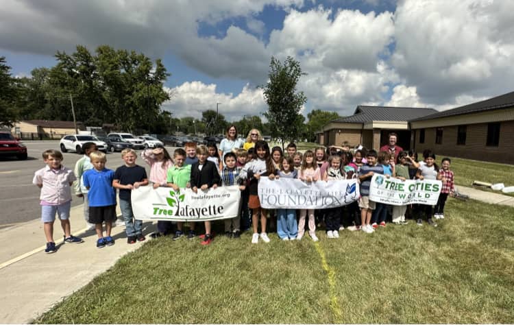 Group of children and adults holding Tree Lafayette and Lafayette Life Foundation banners